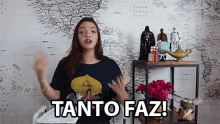 a woman is standing in front of a map and says " tanto faz "