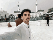 a man taking a picture of himself in front of a building with a sign that says ' a ' on it