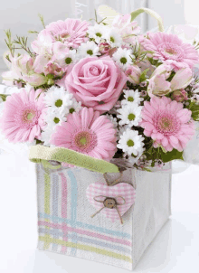 a box of pink and white flowers with a heart on it