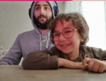 a man with a beard and headphones is sitting next to a little girl wearing glasses