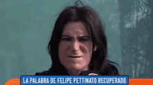 a woman is making a funny face in front of a sign that says la palabra de felipe pettinato recuperado