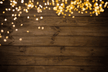 a wooden background with a string of lights on it