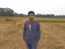 a man wearing a shirt that says ' i ' on it is standing in a field