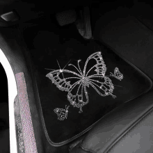 a black mercedes car mat with a butterfly design