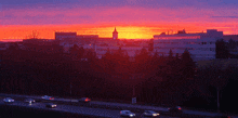 a sunset over a city with a tower in the background