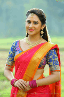 a woman in a red saree with a blue blouse