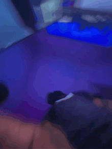 a blurry picture of a person laying on a purple surface