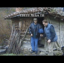 two men are standing in front of a small wooden building with the words eeee leba ti written on it