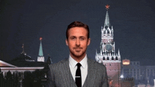 a man in a suit and tie is standing in front of a clock tower ..