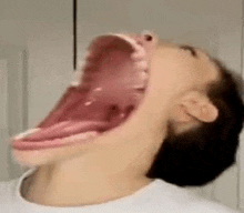 a close up of a person 's mouth with a very large open mouth .