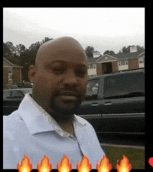 a man in a white shirt is standing in front of a truck