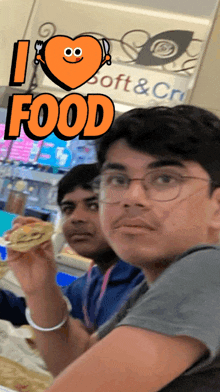 a man holding a sandwich in front of a sign saying i love food