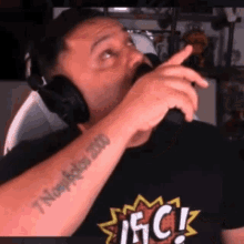 a man is wearing headphones and has a tattoo on his arm that says 7 nov october 2000