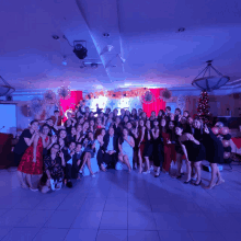 a group of people are posing for a picture in a room with a christmas tree in the background