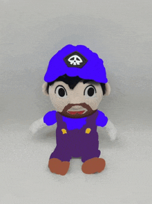 a stuffed toy of a man with a beard wearing a blue hat with a skull on it