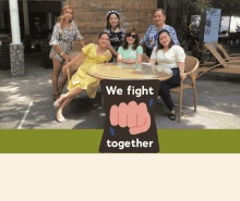 a group of women posing for a picture with a sign that says we fight together