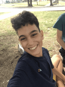 a boy wearing a national geographic t-shirt smiles for the camera