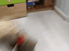 a blurry picture of a person 's feet in a room with a green drawer in the background