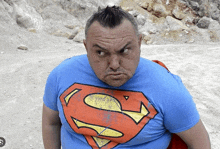 a man with a mohawk wears a blue superman t-shirt