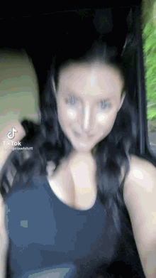 a woman is taking a selfie in a car with her breasts visible .