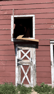 a red building with a white door and a window