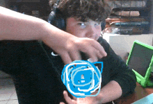 a boy wearing headphones has a drawing of a blue circle on his chest