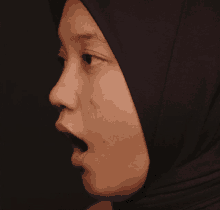 a woman wearing a black hijab has her mouth open