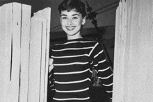 a woman wearing a black and white striped shirt is smiling