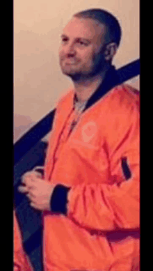 a man wearing an orange jacket with the number 9 on the front