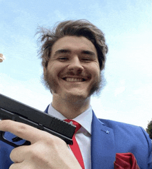 a man in a blue suit holds a gun in his right hand