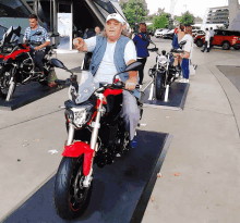 a man sitting on a red and black motorcycle with a bmw logo on the side