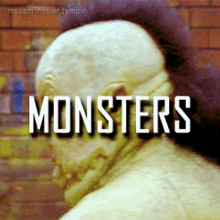 a man with a mohawk is standing in front of a brick wall with the word monsters written on it