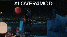 a man is standing in front of a computer screen with the words # lover4mod written above him .