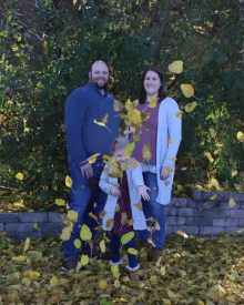 a family is posing for a picture with leaves flying around them