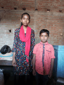 a boy in a red shirt stands next to a girl