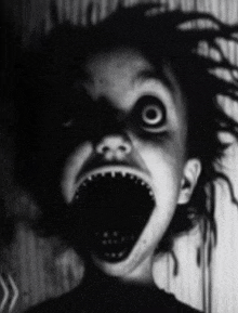 a black and white photo of a scary child with a large open mouth