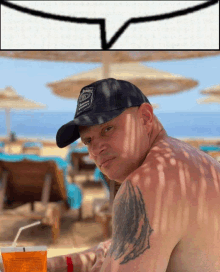 a man wearing a jack daniels hat is sitting on the beach