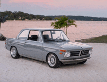 a bmw is parked on a sandy beach