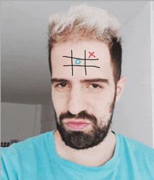 a man with a beard has tic tac toe drawn on his face