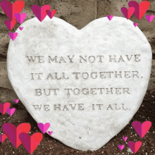 a heart shaped stone has a quote on it that says we may not have it all together but together we have it all