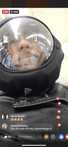 a man wearing a helmet with a bubble around his head is live on facebook