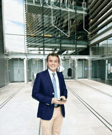 a man in a suit and tie is standing in front of a building with a sign that says ' emergency exit ' on it