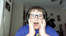 a young boy wearing glasses and headphones looks surprised