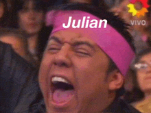 a man wearing a pink headband that says julian