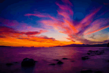 a painting of a colorful sunset over the ocean