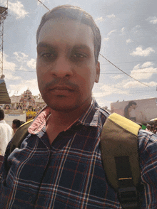 a man wearing a plaid shirt and carrying a backpack