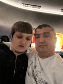 a man and a boy are posing for a picture and the boy is wearing a shirt that says ' a '