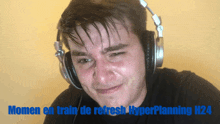 a man wearing headphones with the words " moment en train de refresh hyperplanning n24 " below him