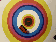 a red toy bus is driving through a colorful target