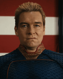 a close up of a man 's face with a red white and blue flag in the background